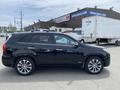 A 2015 Kia Sorento in black with sleek body lines and alloy wheels parked on a lot