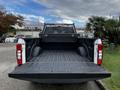 A 2020 Ford F-250 SD truck with an empty bed and a black bedliner is shown from the rear angle