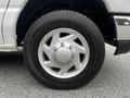 Close-up of a silver wheel of a 2008 Ford Econoline featuring a five-spoke design and a Sumitomo tire