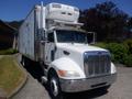 A white 2008 Peterbilt 335 truck with a refrigerated box trailer and a front grille featuring horizontal chrome bars