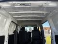 Interior view of a 2017 Nissan NV200 showing the ceiling and two front seats with a central console in the foreground