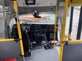 Interior view of a 2017 Chevrolet Express showing the driver's seat dashboard and controls with yellow handrails and a fire extinguisher on the floor