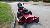 A red 2014 Ferris Mower ISX 800 with a comfortable seat and large rear tires is parked on a paved surface