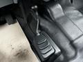 A gear shifter for a 2015 Ford F-550 positioned on the floor with a textured surface and additional controls next to it