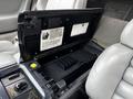 The interior of a 1992 Chevrolet Corvette showing a compartment with a lid open revealing storage space and controls