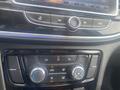 Dashboard controls of a 2018 Buick Encore featuring climate control knobs and buttons for air settings and audio system