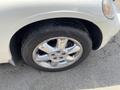 A close-up view of the front wheel of a 2005 Chrysler PT Cruiser showcasing the chrome alloy rim and tire tread