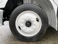 Close-up of a white wheel and tire from a 2019 Freightliner M2 showing lug nut details and tread pattern