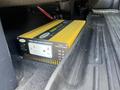 A 2014 Ford F-150 with a pure sine wave inverter on the floorboard, featuring electrical outlets and a yellow casing