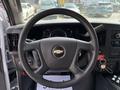 Steering wheel of a 2020 Chevrolet Express with a Chevrolet logo and dashboard controls visible