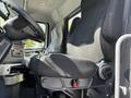 2005 Volvo VND 122 driver's seat with fabric upholstery and armrest visible from an angle showing dashboard controls and interior details