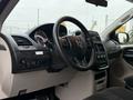 Interior of a 2011 Dodge Grand Caravan featuring a steering wheel dashboard controls and center console with various buttons and knobs