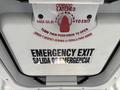 A close-up view of the emergency exit door inside a 2018 Chevrolet Express with instructions in English and Spanish