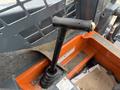 A close-up view of the control lever of a 2017 Gehl R105 skid steer loader featuring a black handle and a textured grip
