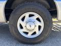 A silver wheel with five spokes and a Goodyear tire marked with rugged tread patterns on a 2008 Ford E-350