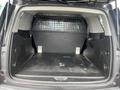 A 2016 Chevrolet Tahoe with an empty cargo space featuring a divider and a rubberized floor liner
