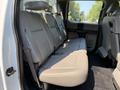 A 2018 Ford F-550 with a spacious rear seating area featuring beige leather upholstery and seat belts