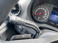 A close-up of a 2025 Mercedes-Benz Sprinter steering wheel with a multifunction control stalk and dashboard displaying speedometer and other gauges