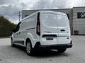 A white 2019 Ford Transit Connect van parked with its rear doors closed and empty license plate holder visible