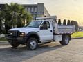 A 2006 Ford F-550 truck with a dump bed designed for heavy-duty work featuring a white exterior and a utility-style body