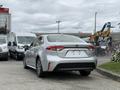 A silver 2025 Toyota Corolla parked with its rear view prominently displayed