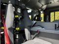 Interior view of a 2006 Emergency One Fire Truck showing seats with safety straps and a console area with controls and storage