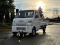 A white 2008 Suzuki Carry truck positioned in the foreground with a compact design and flatbed for transporting goods