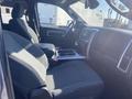 Interior view of a 2021 RAM 1500 showcasing two gray front seats and a center console with storage compartments and cup holders