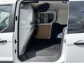 Interior view of a 2016 Ford Transit Connect showing the cargo area with a partition wall and black flooring
