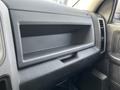 Interior view of a 2015 RAM 1500 showing an empty glove compartment with a textured black finish