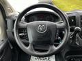 The steering wheel of a 2021 RAM Promaster with control buttons and dashboard instruments visible behind it