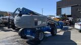 A 2008 Genie S-65 Boom Lift with a gray and blue body and large wheels designed for lifting personnel and equipment to elevated areas