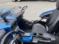 A blue 2020 Polaris Slingshot interior featuring a steering wheel dashboard display and a single black seat with a minimalist design