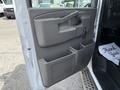 The interior driver's side door of a 2017 Chevrolet Express featuring a handle a manual window crank and storage compartments