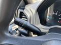 Close-up of the turn signal lever inside a 2015 Ford F-150 with controls for headlights and windshield wipers visible
