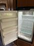 An open refrigerator with several shelves and drawers inside showing a spacious and clean interior