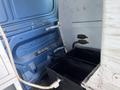 Interior view of a 2009 Ford Econoline with blue walls featuring two black storage bins and mounting brackets on the side