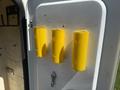 Three yellow cylindrical objects mounted on a white panel with visible holes and a keyhole below them