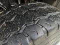 Close-up of a heavy-duty truck tire showing tread patterns and small debris embedded in the rubber surface