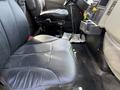 The interior of a 2009 International 7500 featuring a black leather driver's seat and controls including a gear shift and various dashboard elements