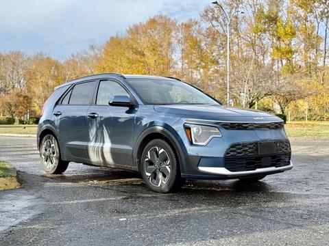 A blue 2023 Kia Niro EV parked with a sleek design featuring a modern front grille and distinctive headlights