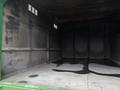 Interior of a 2015 Freightliner M2 106 truck with a dark, industrial appearance featuring metal walls and a flat floor showing signs of wear and oil stains