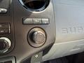Close-up of the dashboard controls of a 2014 Ford F-250 SD including buttons for air conditioning and a circular dial for voltage adjustment