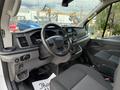 Interior of a 2021 Ford Transit showing the dashboard steering wheel and front seats with controls and a display screen