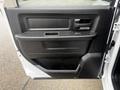 The interior door panel of a 2022 RAM 1500 Classic featuring a textured black surface with a handle cup and controls for windows and locks