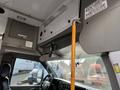 Interior view of a 2018 Chevrolet Express showing the dashboard a yellow grab bar and a rearview mirror mounted on the ceiling