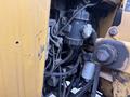 A close-up view of the engine compartment of a 2015 Vermeer Corporation BC1200XL with visible components like wires and mechanical parts