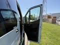 A 2023 Mercedes-Benz Sprinter van with a wide open side door showcasing the interior seating and dashboard area