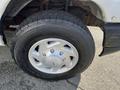 Close-up of a tire and wheel of a 2008 Ford Econoline showing a silver hubcap and tread pattern
