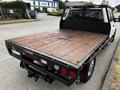 A 2020 Ford F-350 with a flatbed design featuring a wooden surface and rear lights visible on the back of the truck